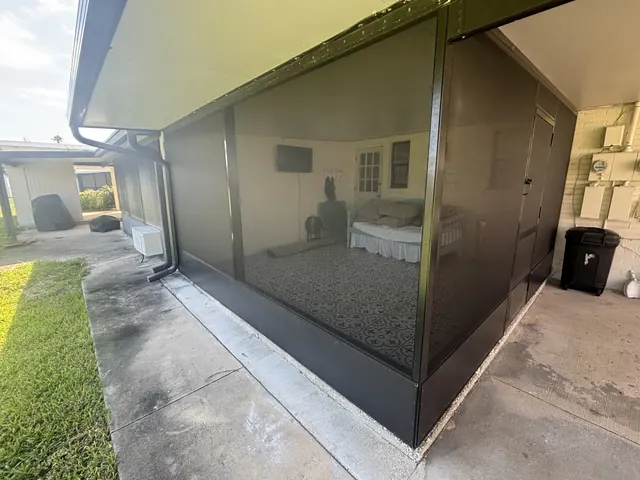 Finished side of a covered enclosure with screened walls and solid lower kick plates